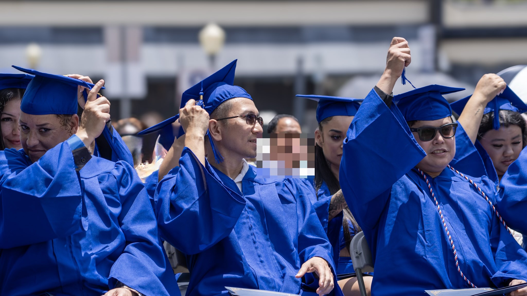 Graduates seated and smiling during the commencement ceremony